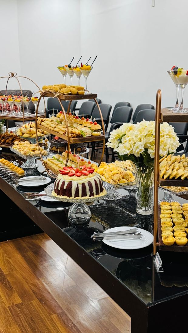 Mesa sofisticada com bolo, mini sobremesas, flores e salgados