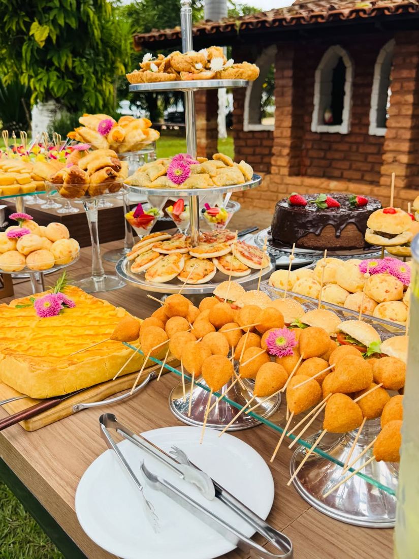 Brunch montado ao ar livre com pães, frutas, sucos e doces