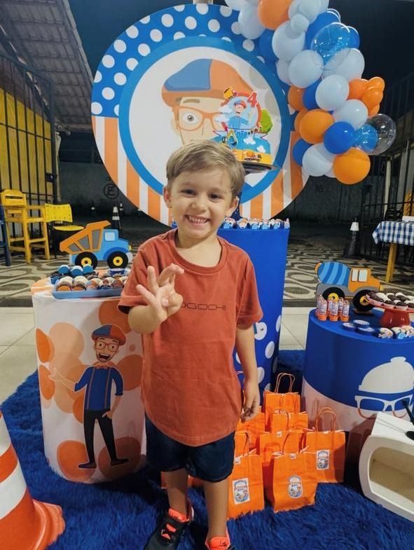 Menino sorrindo na festa de 4 anos com decoração temática e balões