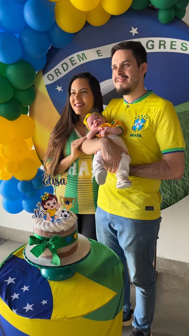 Pais com a bebê na comemoração de 1 mês, com bolo e balões